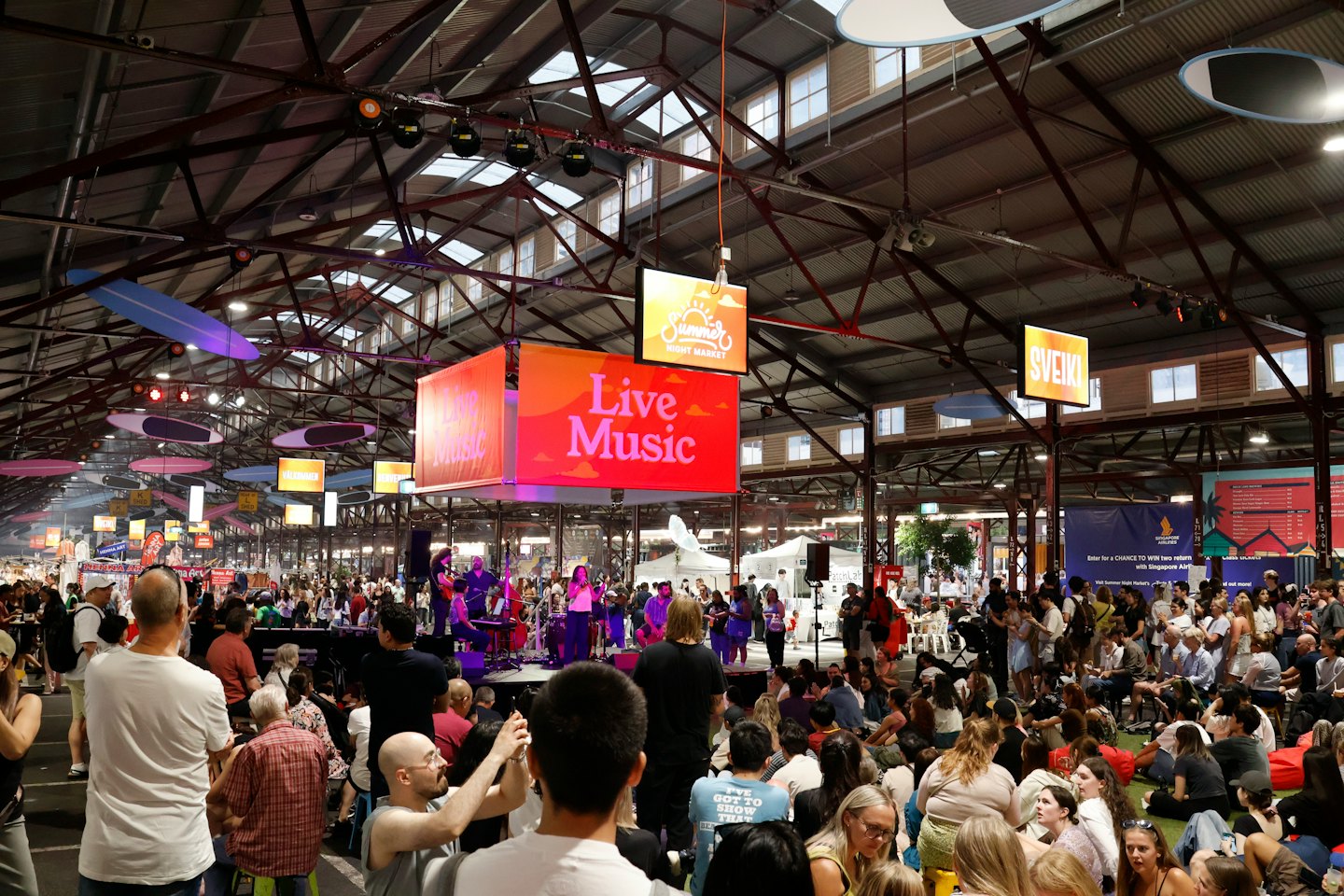 People gather in an industrial space to watch a performance.